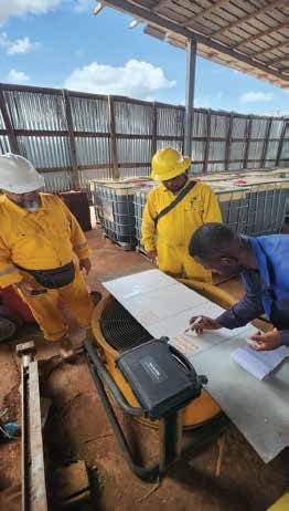 Inspectors recording results under a field shelter
