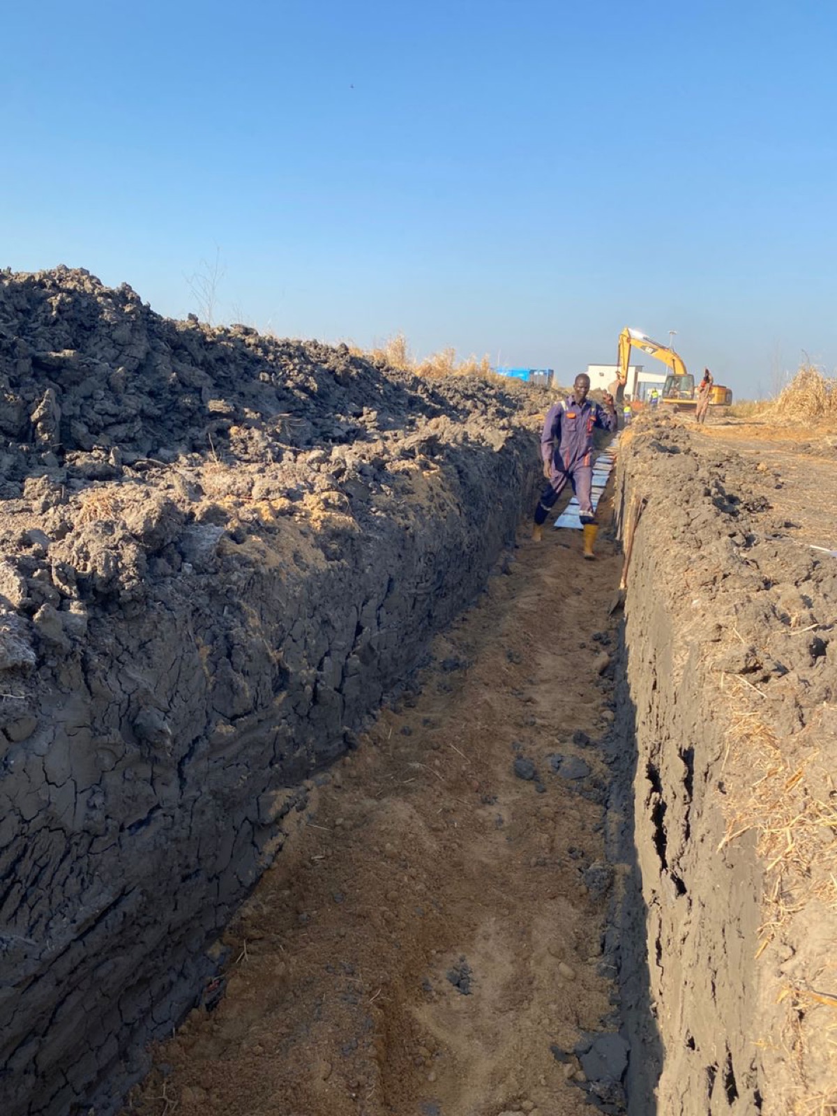Trench excavation continuing across the field