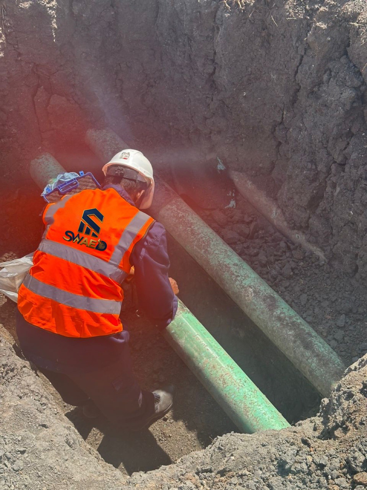 Inspector working on parallel flowlines in an excavation